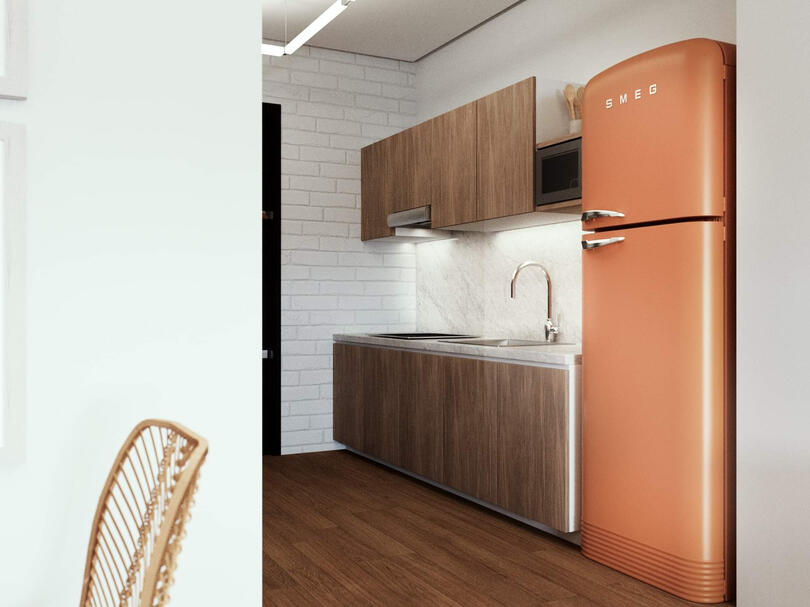 The small kitchen is equipped with ample storage space with warm wood paneling.